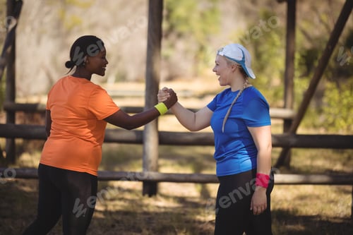 Preview: Happy Friend Holding Hands During Obstacle Course In Boot Camp