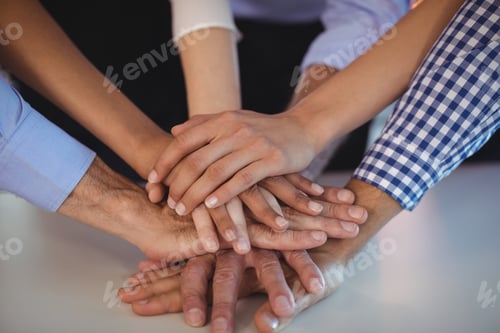 Preview: Close Up Of Business Colleagues Stacking Their Hands On Desk In Office