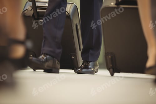 Preview: Low Section Of Businessman With Trolley Bag Walking