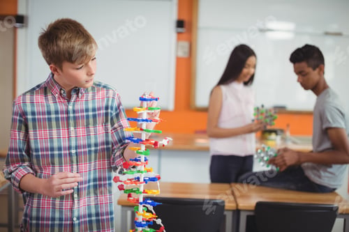 Preview: Schoolboy Examining Molecule Model In Laboratory At School