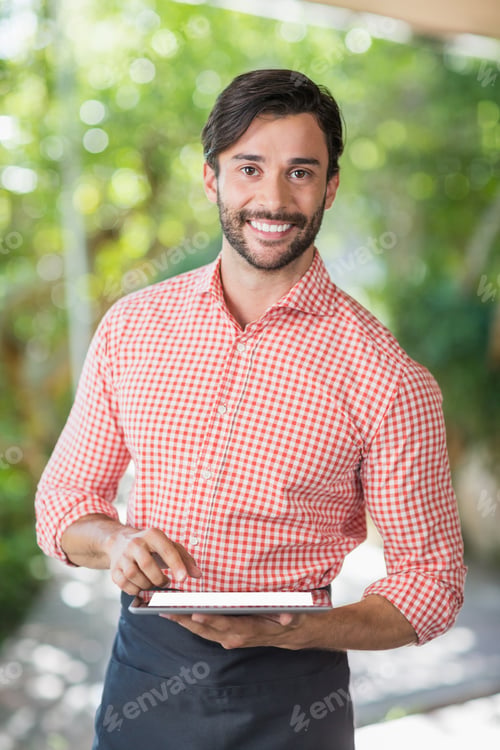 Preview: Portrait Of Male Waiter Using Digital Tablet