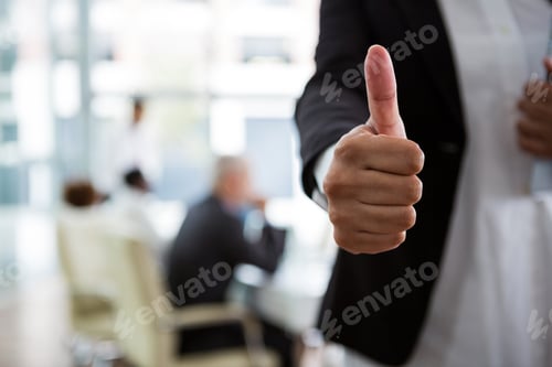 Preview: Mid Section Of Businesswoman Showing Thumbs Up In Office