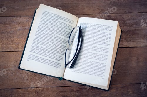 Preview: Close Up Of Eyeglasses On Book At Wooden Table