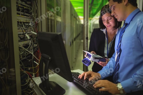 Preview: Technicians Using Digital Cable Analyzer While Working On Personal Computer In Server Room