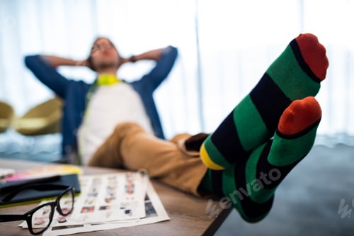 Preview: Casual Man Resting With Feet On His Desk In Modern Office