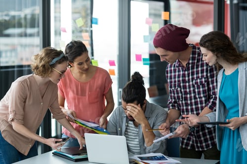 Preview: Colleagues With Digital Tablet And Mobile Phone Talking To Frustrated Man In Office