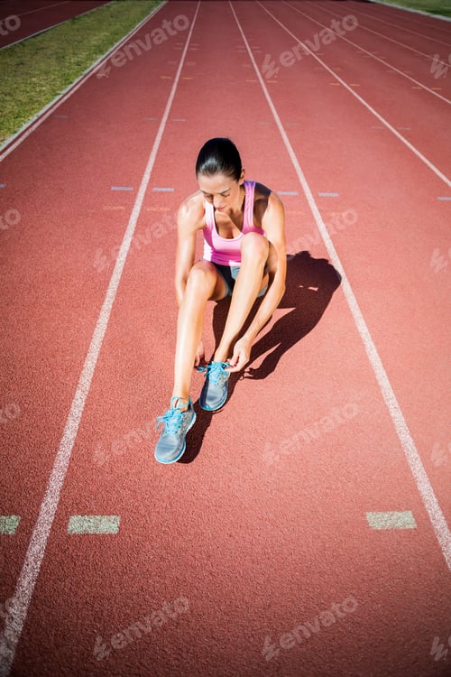 Preview: Female Athlete Tying Her Running Shoes On Running Track