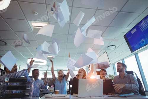 Preview: Cheerful Business People Tossing Papers Against Ceiling In Office