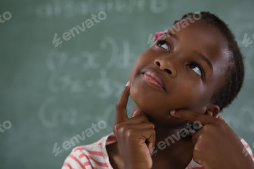 Preview: Thoughtful Schoolgirl Sitting Against Chalkboard
