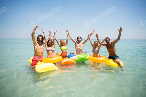 Preview: Portrait Of Cheerful Friends Enjoying On Inflatable Rings And Pool Rafts In Sea Against Sky