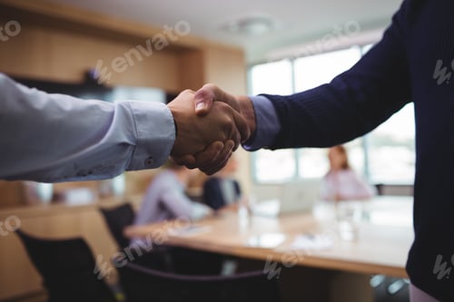 Preview: Cropped Image Of Business People Shaking Hands During Meeting In Board Room