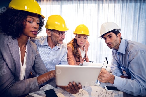 Preview: Architects Discussing Over Digital Tablet During Meeting In Office
