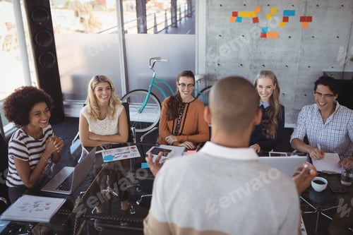 Preview: Rear View Of Businessman Giving Presentation To Colleagues In Board Room At Office
