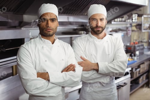 Preview: Portrait Of Two Chefs Standing Together With Arms Crossed In Commercial Kitchen At Restaurant