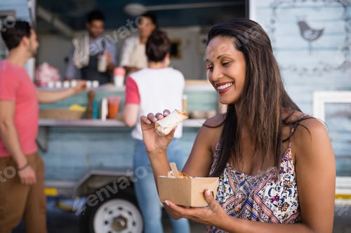 Preview: Woman Sitting On Bench And Eating Wrap
