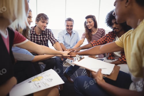 Preview: Group Of Confident Business People Stacking Hands While Sitting Creative Office