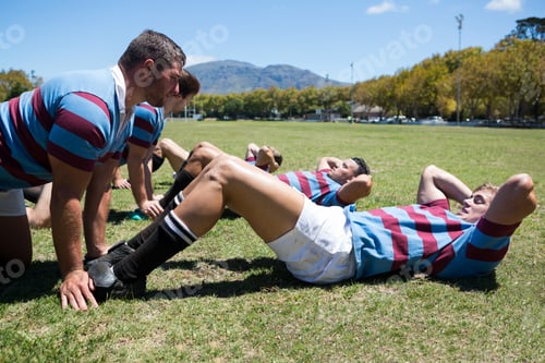 Preview: Rugby Players Exercising On Field Against Clear Sky