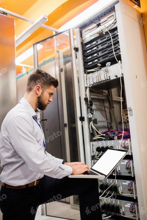 Preview: Technician Using Laptop While Analyzing Server In Server Room