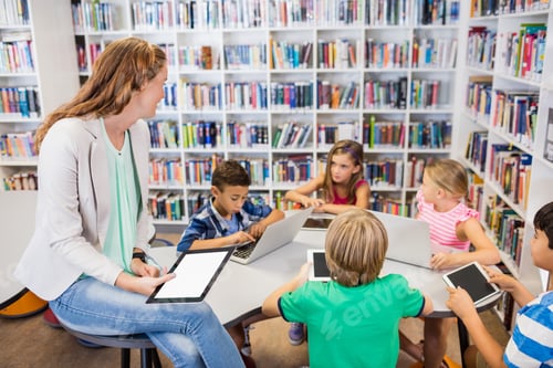 Preview: Young Pretty Teacher Having Lesson To Children With Their Tablet At School