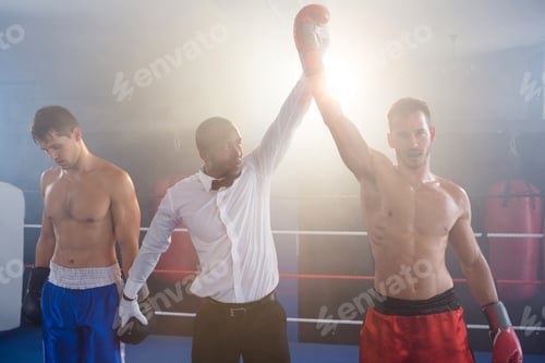 Preview: Referee Lighting Hand Of Winner Standing With Loser In Boxing Ring