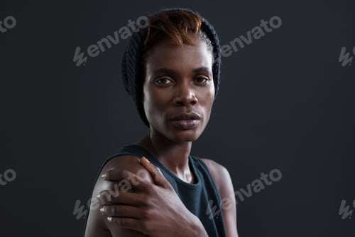 Preview: Androgynous Man Touching His Shoulder Against Grey Background