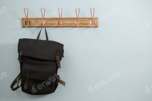 Preview: Black Backpack Hanging on a Wooden Wall Rack
