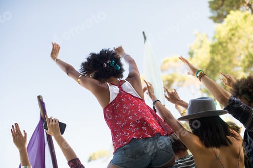 Preview: Tilt Image Of Friends With Arms Raised Against Sky Enjoying At Music Festival