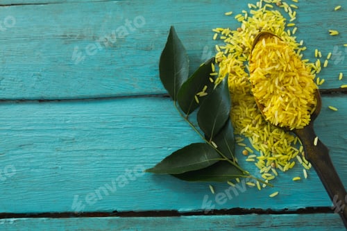 Preview: Close-Up Of Raw Organic Yellow Rice And Curry Leaves On Wooden Table
