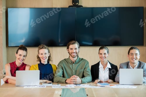 Preview: Portrait Of Smiling Business Team Sitting In Conference Room At Office