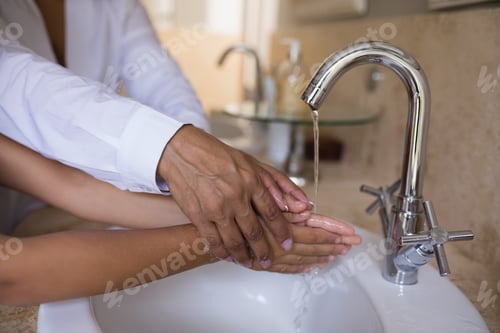 Preview: Mid Section Of Granny Helping Girl While Washing Hands At Sink In Bathroom, Coronavirus Hand
