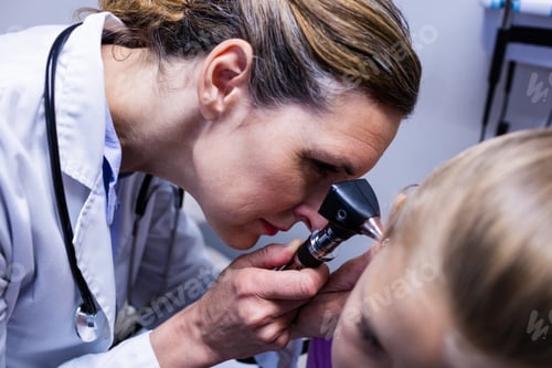 Preview: Female Doctor Examining Patient Ear With Otoscope In Hospital