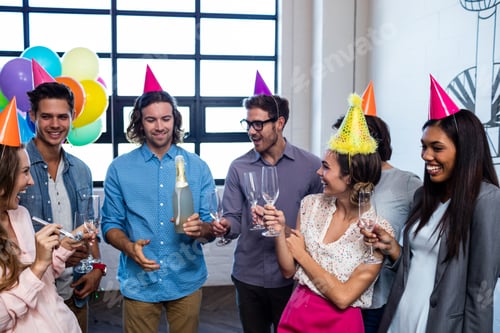 Visualização: Colega de trabalho feliz abrindo uma garrafa de champanhe para aniversário no escritório