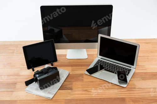 Preview: Computer, Laptop, Digital Tablet, Mobile Phone, Virtual Headset And Newspaper On Wooden Table