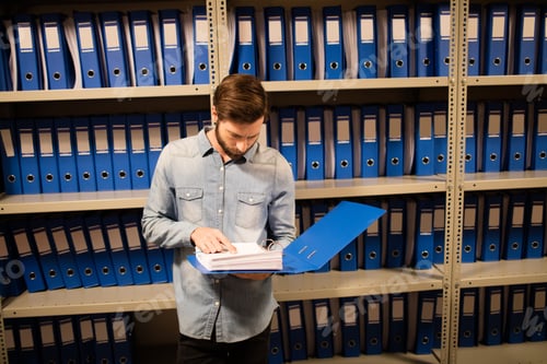 Preview: High Angle View Of Businessman Reading File While Standing In Storage Room