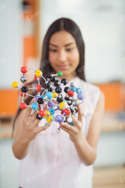 Preview: Attentive Schoolgirl Experimenting Molecule Model In Laboratory At School