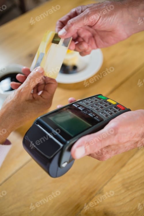 Preview: Senior Woman Making Payment Through Credit Card In Cafã©