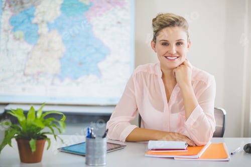 Preview: Portrait Of Teacher Sitting In Classroom At School