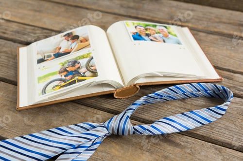 Preview: High Angle View Of Photo Album By Necktie On Wooden Table