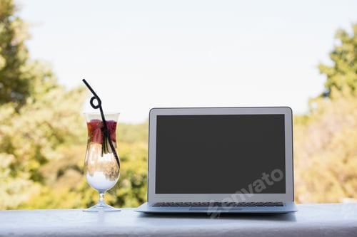 Preview: Close Up Of Laptop And Cocktail Drink On Retaining Wall At Restaurant