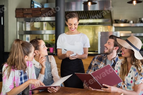 Preview: Smiling Waitress Writing Orders Of Customers In Restaurant