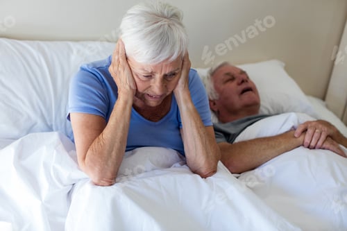 Preview: Senior Woman Getting Disturbed With Man Snoring On Bed In Bedroom