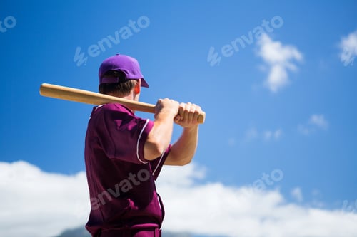 Preview: Low Angle Side View Of Baseball Player Holding Bat Against Blue Sky On Sunny Day