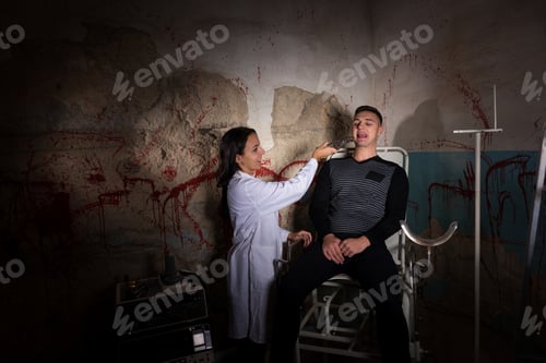 Preview: Crazy Scientist Holding Medical Forceps In Front Of Patient In Dungeon With Bloody Walls In A