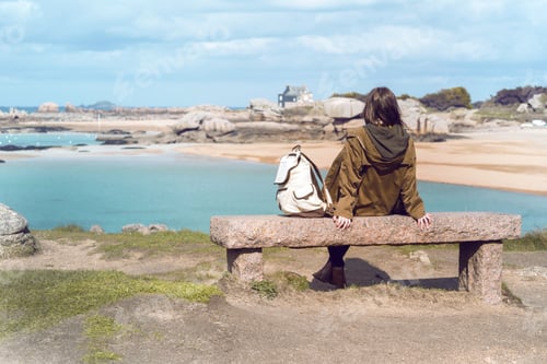 Preview: Girl Traveler Sits On A Bench Near The Sea And The Shore At The Tregastel, Brittany. France