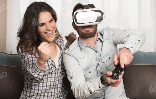 Vista previa: Pareja jugando videojuegos en casa con gafas de realidad virtual