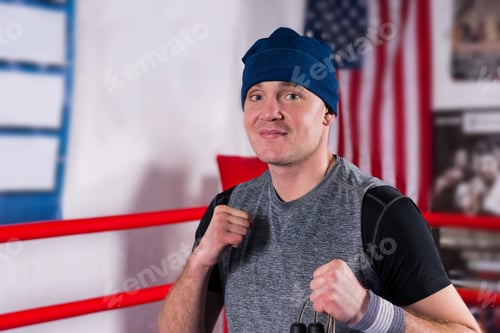 Preview: Male Boxer Standing In A Pose Clenching His Fists In A Regular Boxing Ring Surrounded By Ropes In A