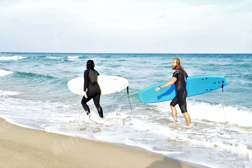 Preview: Surfers Couple Waiting For The High Waves On Beach - Sporty People With Surf Boards On The Beach