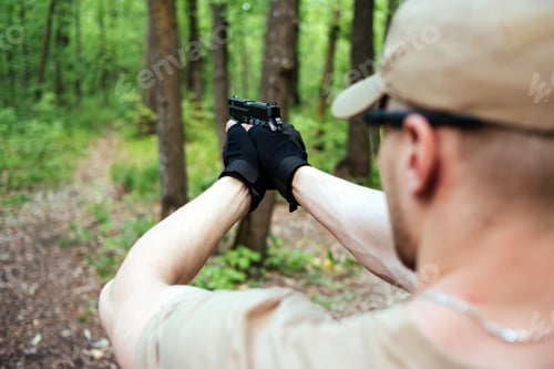 Preview: Guy With Arms In The Woods Is Aiming And Posing At The Camera