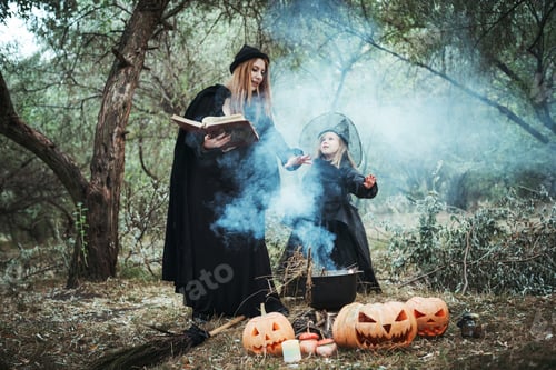 Preview: Adult Witch And Small Witch Making Magic In The Wood. Mother And Daughter In Halloween Costumes