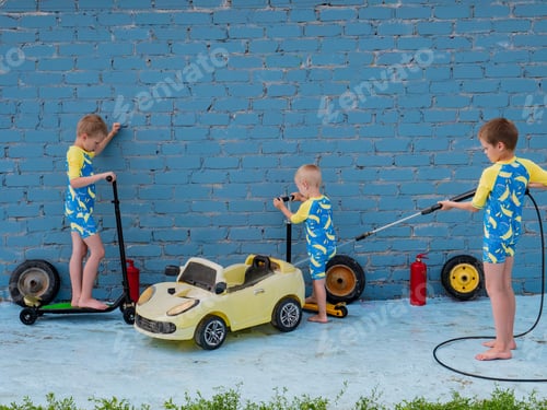 Preview: Funny Children In Boys' Bathing Suits Posing In Front Of Camera With High-Pressure Car Wash And Toy